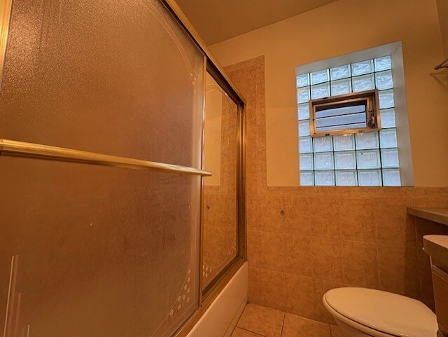 8834 S E End Ave, Chicago, IL 60617 - bathroom with toilet, tile walls, tile patterned floors, enclosed tub / shower combo, and vanity