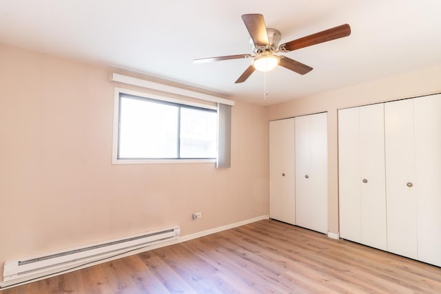 6319 W 64th Pl Unit 1N, Chicago, IL 60638 - unfurnished bedroom with a baseboard heating unit, two closets, light wood-type flooring, and ceiling fan