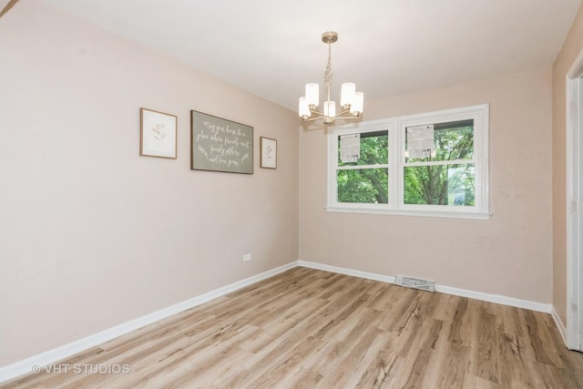 407 Greenfield Rd, Shorewood, IL 60404 - spare room featuring a chandelier, light wood-type flooring, and baseboards