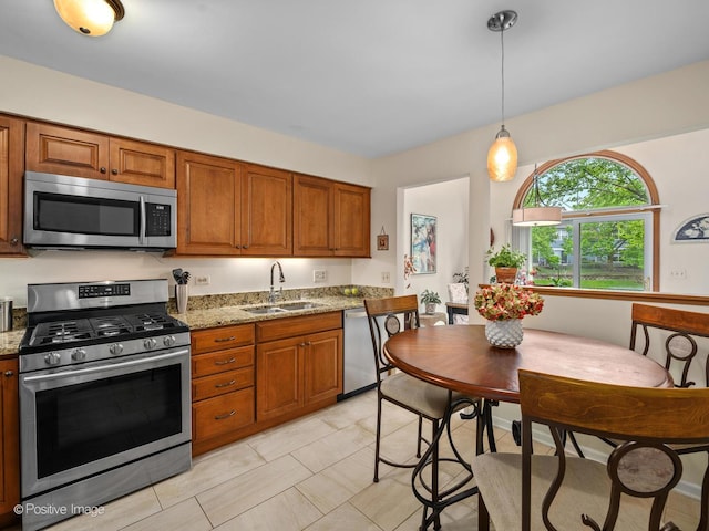 1937 N Coldspring Rd, Arlington Heights, IL 60004 - kitchen with stainless steel appliances, a sink, brown cabinets, decorative light fixtures, and light stone countertops