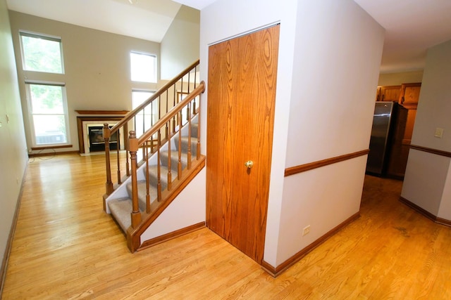 176 Millers Xing, Itasca, IL 60143 - stairs with wood finished floors, a tiled fireplace, and baseboards