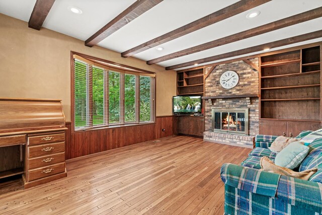19N050 Felsmith Rd, Hampshire, IL 60140 - living room featuring a wainscoted wall, beamed ceiling, light wood finished floors, wooden walls, and a brick fireplace