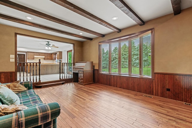 19N050 Felsmith Rd, Hampshire, IL 60140 - living area with a wainscoted wall, beam ceiling, healthy amount of natural light, wood walls, and light wood-style floors