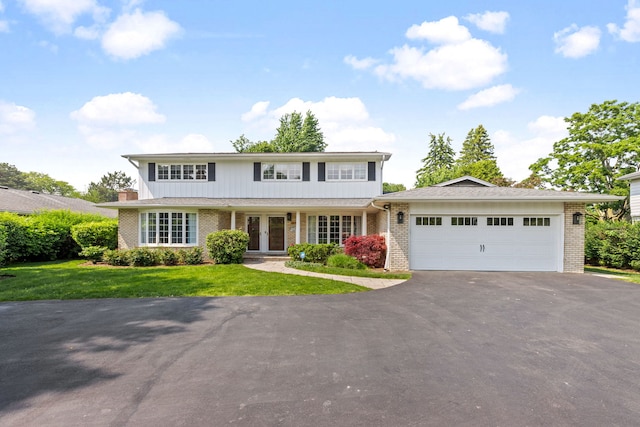 2510 Marian Ln, Wilmette, IL 60091 - traditional-style house with driveway, brick siding, an attached garage, and a front yard