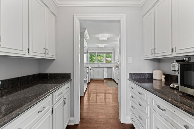 2510 Marian Ln, Wilmette, IL 60091 - kitchen with appliances with stainless steel finishes, white cabinets, dark wood-style flooring, dark stone counters, and crown molding