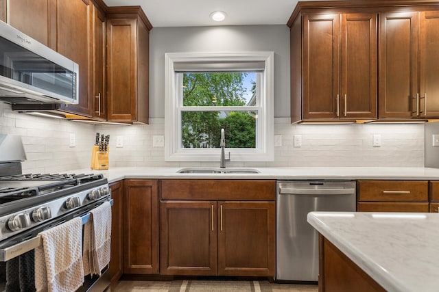 1912 Oak Park Dr, Champaign, IL 61822 - kitchen with appliances with stainless steel finishes, a sink, light countertops, and backsplash