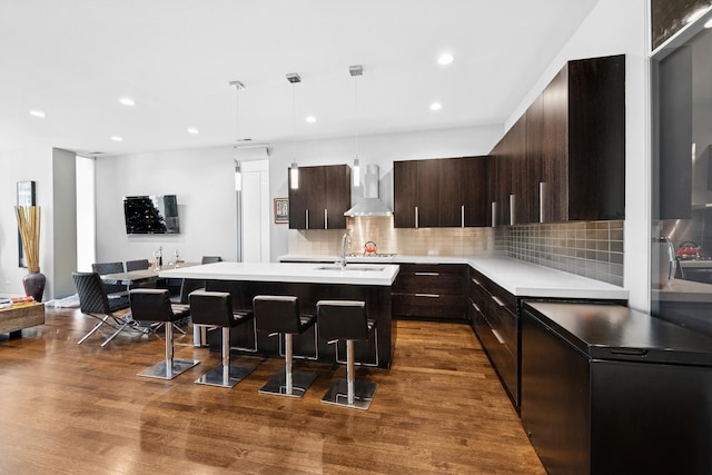 919 N Larrabee St Unit 3N, Chicago, IL 60610 - kitchen with wall chimney exhaust hood, light countertops, a kitchen breakfast bar, an island with sink, and tasteful backsplash