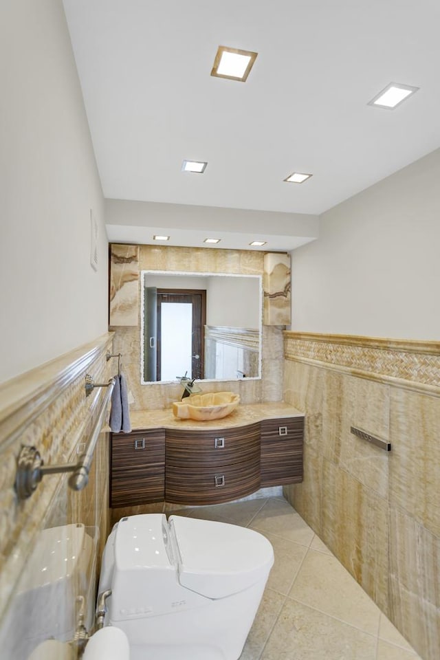 111 E Chestnut St Unit 24C, Chicago, IL 60611 - bathroom featuring tile walls, vanity, toilet, a wainscoted wall, and tile patterned flooring