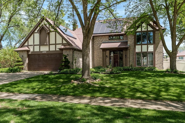 3757 Dynasty Ln, Rockford, IL 61114 - tudor house featuring brick siding, driveway, a garage, and a front lawn