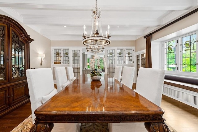 dining area featuring beamed ceiling, a chandelier, and wood finished floors