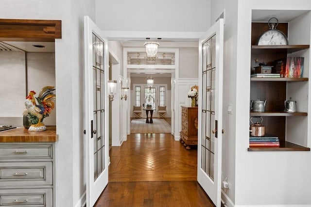 corridor with dark wood finished floors and a chandelier