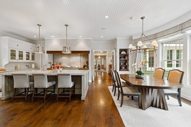 kitchen featuring dark wood finished floors, white cabinets, glass insert cabinets, a large island, and recessed lighting