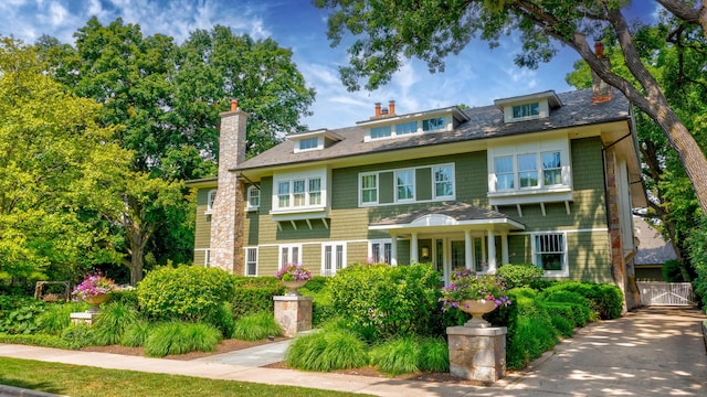 shingle-style home with a chimney and a garage