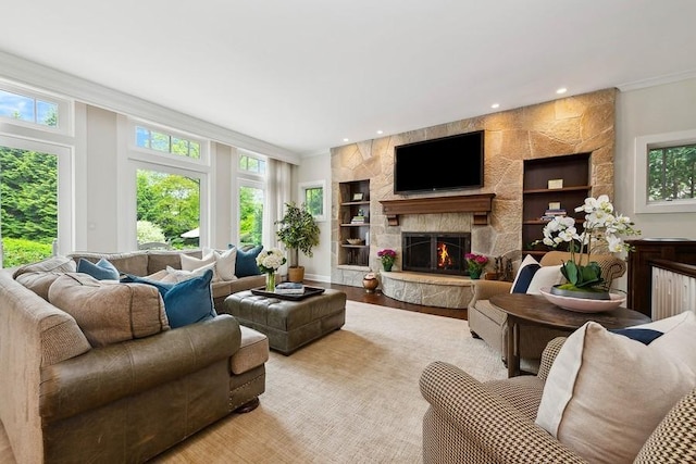 living area featuring built in features, a fireplace, crown molding, recessed lighting, and wood finished floors