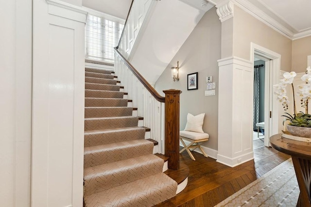 stairway featuring hardwood / wood-style floors and ornamental molding
