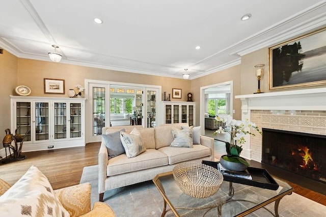 living room with plenty of natural light, wood finished floors, a fireplace, crown molding, and recessed lighting