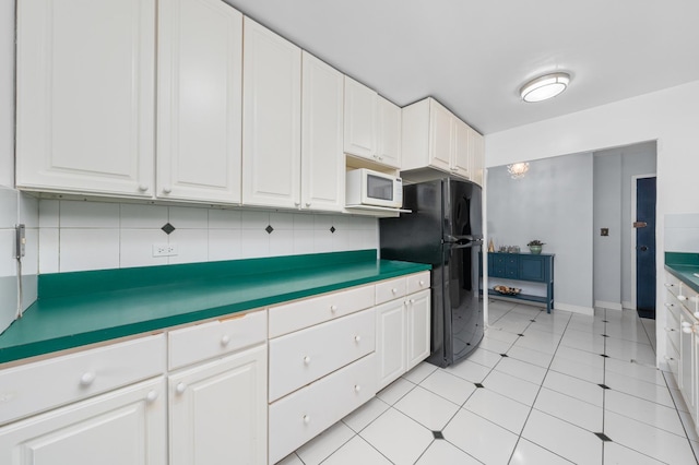 4250 N Marine Dr Unit 1622, Chicago, IL 60613 - kitchen with white microwave, freestanding refrigerator, white cabinets, and decorative backsplash