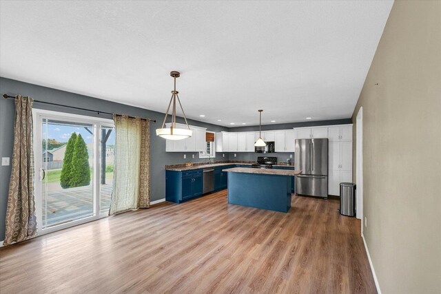 2302 Slade Ln, Mahomet, IL 61853 - kitchen featuring stainless steel appliances, wood finished floors, white cabinets, a kitchen island, and hanging light fixtures