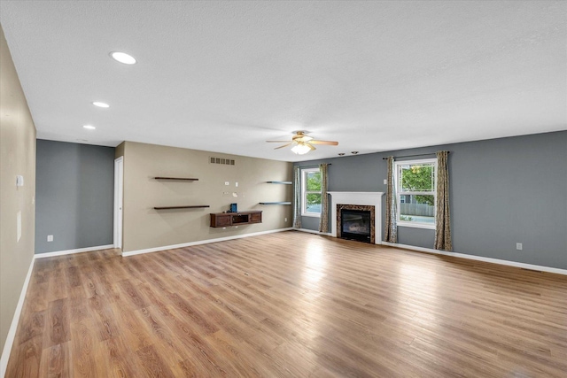 2302 Slade Ln, Mahomet, IL 61853 - unfurnished living room with a ceiling fan, light wood-style flooring, a high end fireplace, and recessed lighting