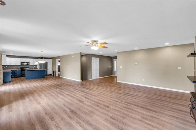 2302 Slade Ln, Mahomet, IL 61853 - unfurnished living room featuring a ceiling fan, light wood-type flooring, and recessed lighting