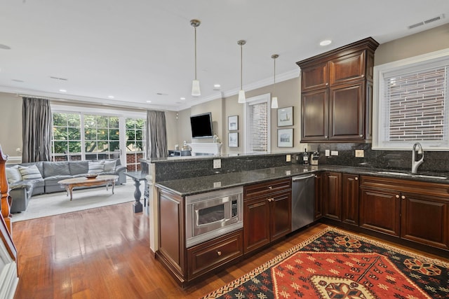 718 W Aldine Ave Unit 3, Chicago, IL 60657 - kitchen featuring a sink, stainless steel appliances, open floor plan, wood finished floors, and crown molding