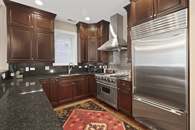 718 W Aldine Ave Unit 3, Chicago, IL 60657 - kitchen with premium appliances, wall chimney exhaust hood, a sink, decorative backsplash, and dark stone countertops