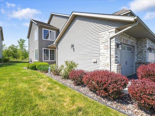 615 Queens Ct Unit 7, Rockton, IL 61072 - view of property exterior featuring a yard, stone siding, and a garage