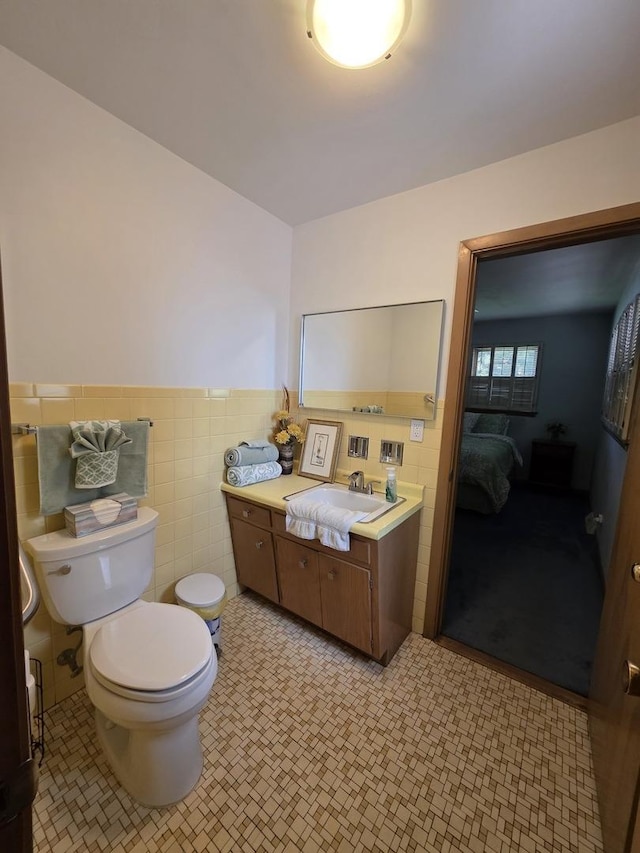 6124 W Berteau Ave, Chicago, IL 60634 - bathroom featuring toilet, vanity, ensuite bath, tile walls, and a wainscoted wall