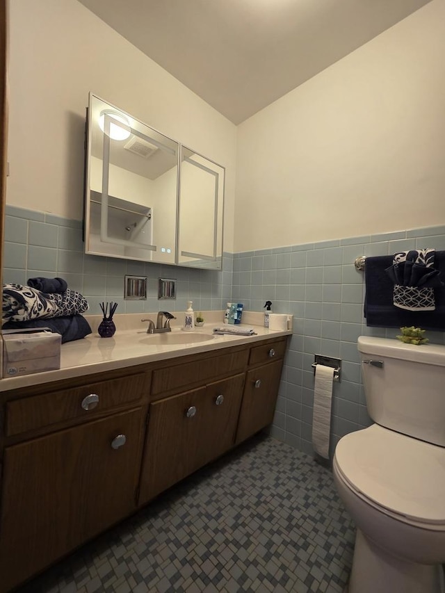 6124 W Berteau Ave, Chicago, IL 60634 - bathroom featuring tile walls, toilet, vanity, and wainscoting