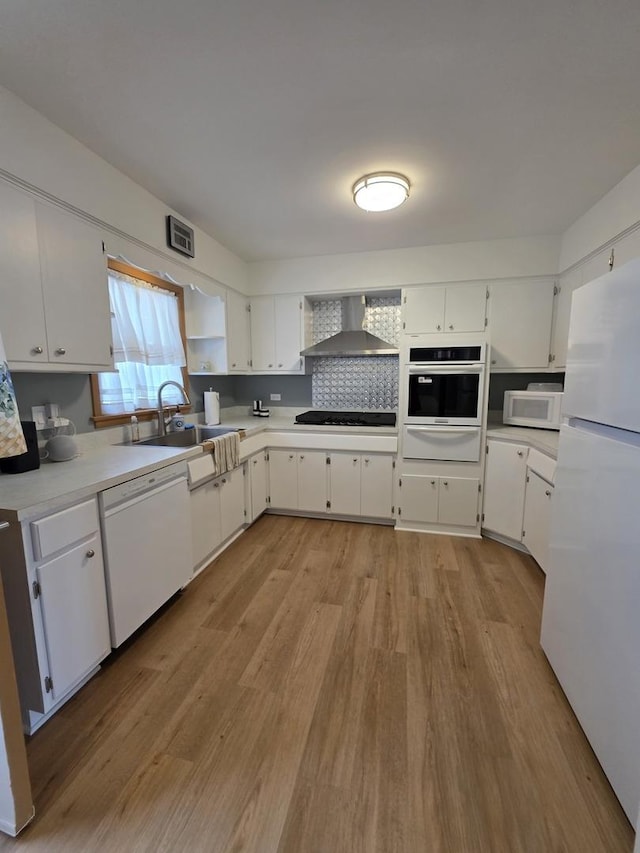 6124 W Berteau Ave, Chicago, IL 60634 - kitchen featuring white appliances, a warming drawer, wall chimney exhaust hood, a sink, and light wood-style floors