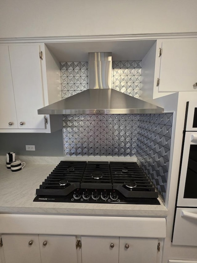 6124 W Berteau Ave, Chicago, IL 60634 - kitchen featuring wall chimney range hood, black gas stovetop, light countertops, backsplash, and a warming drawer