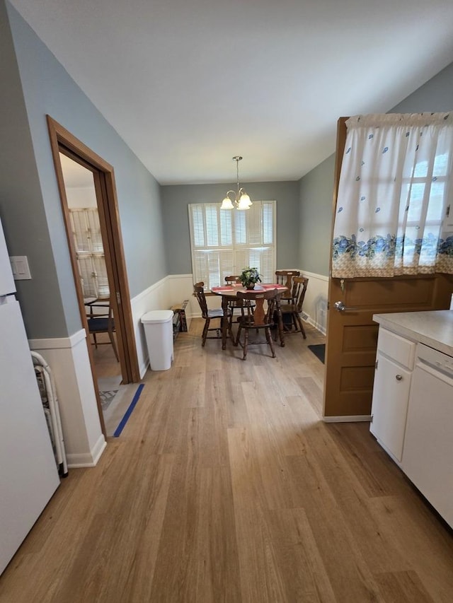 6124 W Berteau Ave, Chicago, IL 60634 - dining space featuring light wood-type flooring, a chandelier, and a wainscoted wall