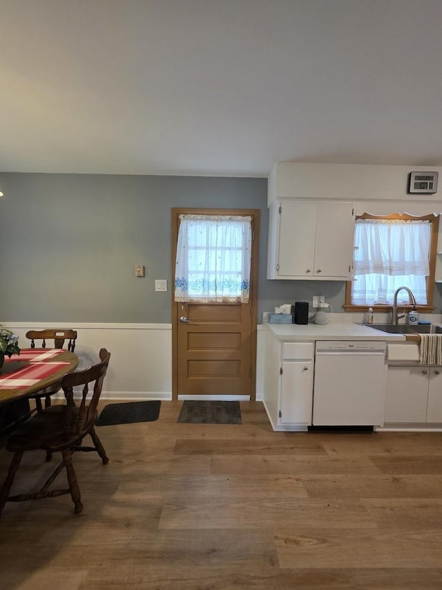 6124 W Berteau Ave, Chicago, IL 60634 - kitchen with white dishwasher, a sink, white cabinetry, light wood-style flooring, and light countertops