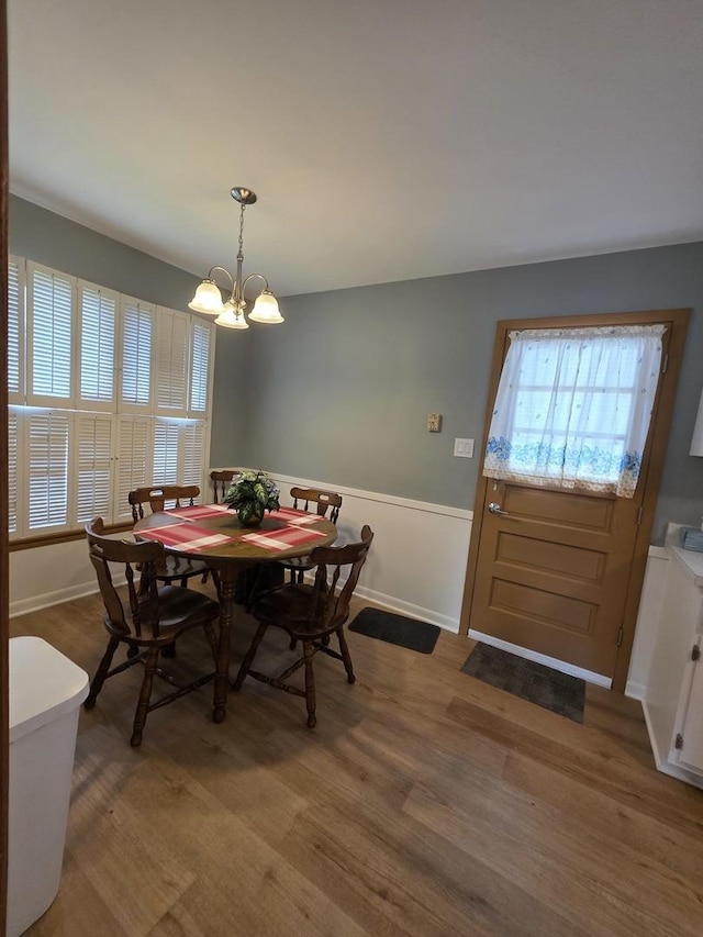 6124 W Berteau Ave, Chicago, IL 60634 - dining space featuring a chandelier, light wood-style flooring, and wainscoting
