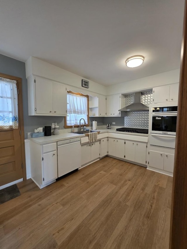 6124 W Berteau Ave, Chicago, IL 60634 - kitchen featuring wall chimney range hood, white appliances, a sink, a warming drawer, and light wood-type flooring