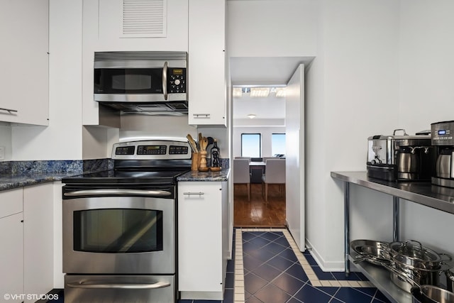 1100 N Lake Shore Dr Unit 33A, Chicago, IL 60611 - kitchen with appliances with stainless steel finishes, white cabinets, dark tile patterned flooring, and baseboards