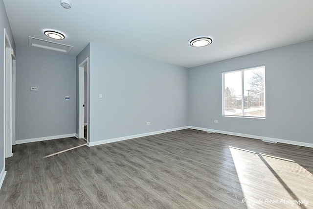 1802 11, Waukegan, IL 60085 - unfurnished room featuring dark wood-style flooring, baseboards, and attic access