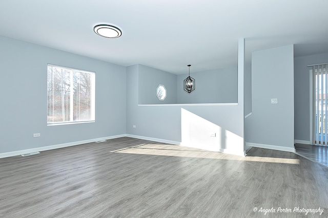 1802 11, Waukegan, IL 60085 - empty room with wood finished floors, baseboards, and a chandelier