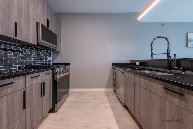 757 N Orleans St Unit 1104, Chicago, IL 60654 - kitchen with stainless steel appliances, a sink, decorative backsplash, light wood-type flooring, and modern cabinets