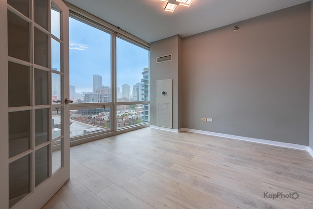757 N Orleans St Unit 1104, Chicago, IL 60654 - empty room featuring floor to ceiling windows, a view of skyline, wood finished floors, and baseboards