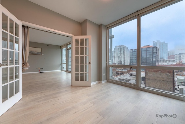757 N Orleans St Unit 1104, Chicago, IL 60654 - unfurnished room featuring french doors, a view of city, wood finished floors, healthy amount of natural light, and a wall of windows