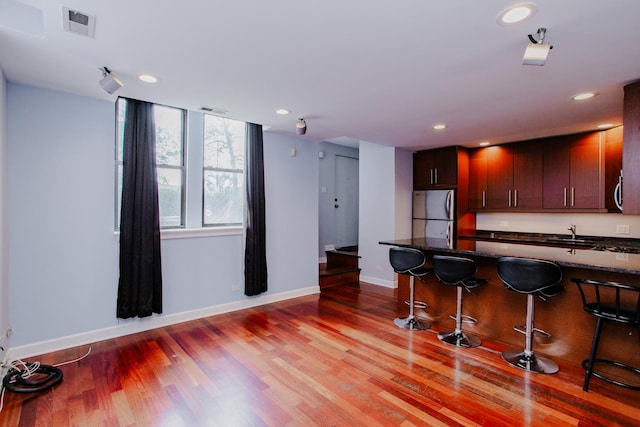 3441 W Grace St Unit G, Chicago, IL 60618 - kitchen with appliances with stainless steel finishes, baseboards, a kitchen bar, light wood-style flooring, and recessed lighting