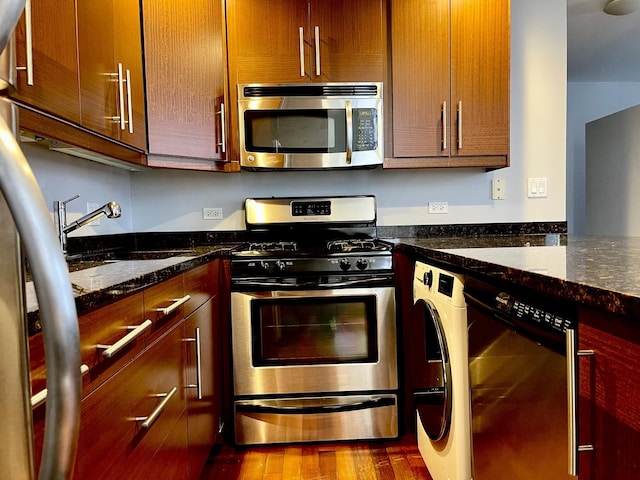 3441 W Grace St Unit G, Chicago, IL 60618 - kitchen with appliances with stainless steel finishes, washer / clothes dryer, wood finished floors, and dark stone countertops