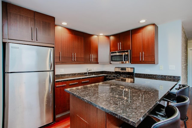 3441 W Grace St Unit G, Chicago, IL 60618 - kitchen with stainless steel appliances, a sink, dark stone countertops, a peninsula, and recessed lighting