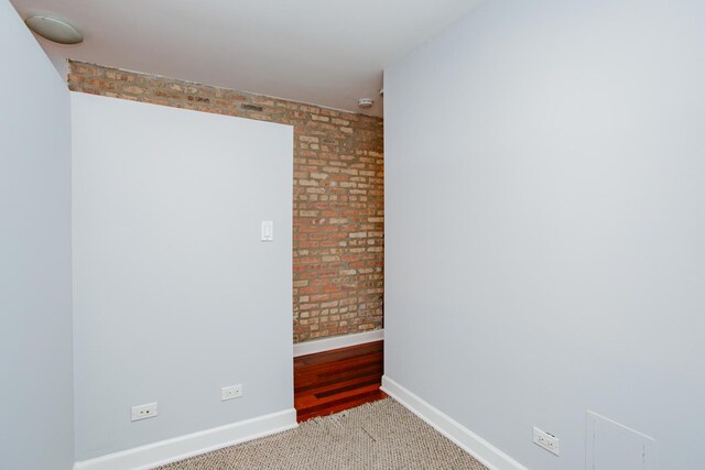 3441 W Grace St Unit G, Chicago, IL 60618 - unfurnished room with baseboards and brick wall