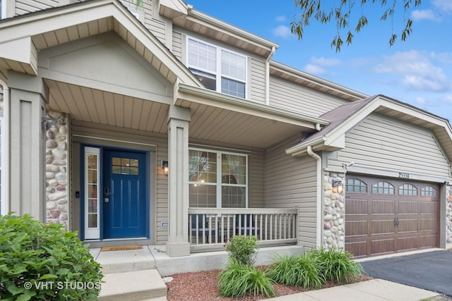 25338 Scott Dr, Plainfield, IL 60544 - view of front of home featuring stone siding, a porch, asphalt driveway, a garage, and a front lawn
