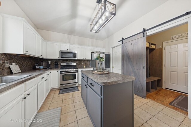 25338 Scott Dr, Plainfield, IL 60544 - kitchen with appliances with stainless steel finishes, light tile patterned floors, white cabinets, decorative backsplash, and a center island