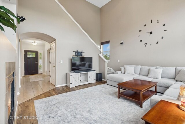 25338 Scott Dr, Plainfield, IL 60544 - living room with arched walkways, wood finished floors, a high ceiling, stairs, and baseboards