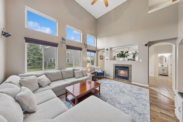 25338 Scott Dr, Plainfield, IL 60544 - living room with ceiling fan, a high ceiling, wood finished floors, a tile fireplace, and arched walkways