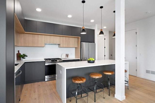 2354 W Farragut Ave Unit Ph-404, Chicago, IL 60625 - kitchen featuring stainless steel appliances, modern cabinets, a breakfast bar, light wood-type flooring, and recessed lighting